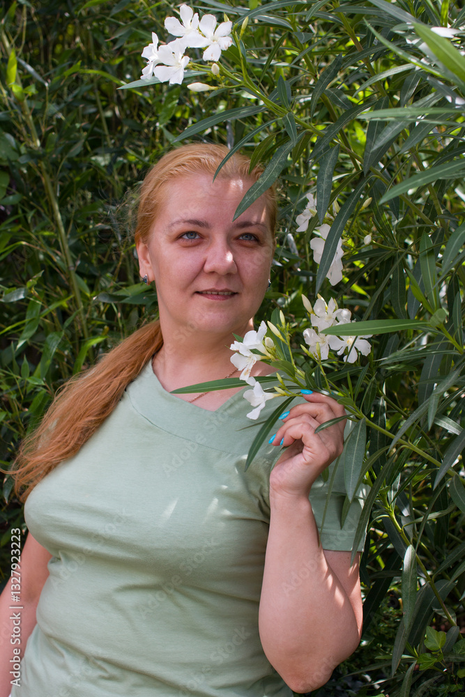 Fototapeta premium A beautiful woman on a walk in the park. The smiling blonde