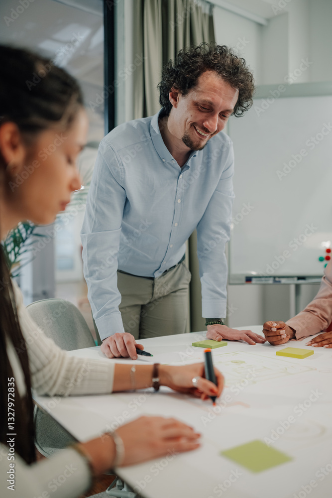 Fototapeta premium Manager smiling and supervising employees working on project