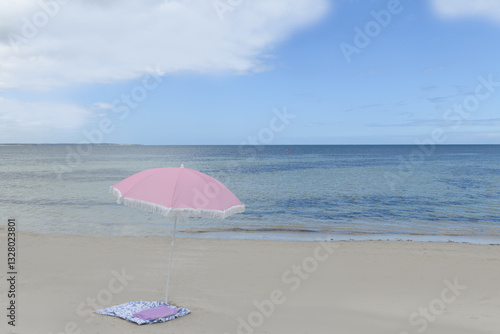 Pink beach umbrella on the coastline