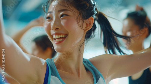 A woman happily dancing in a dance class at a gym studio.
