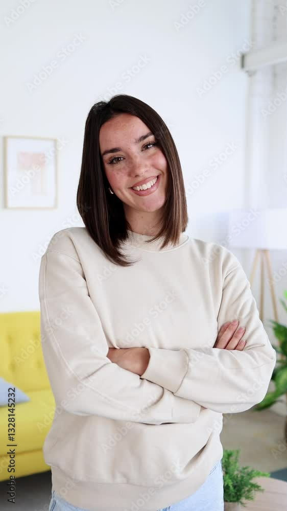 Young woman smiling with crossed arms in living room Young woman smiling with crossed arms in living room