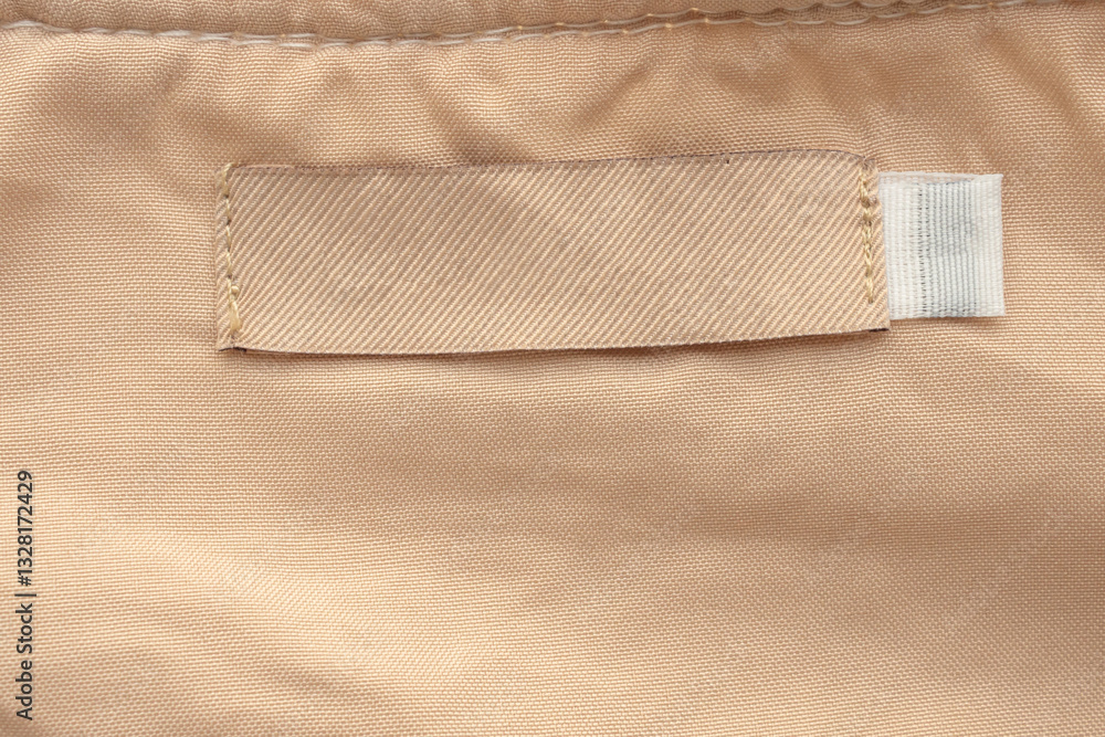 Blank brown laundry care clothes label on brown shirt fabric texture background Blank brown laundry care clothes label on brown shirt fabric texture background