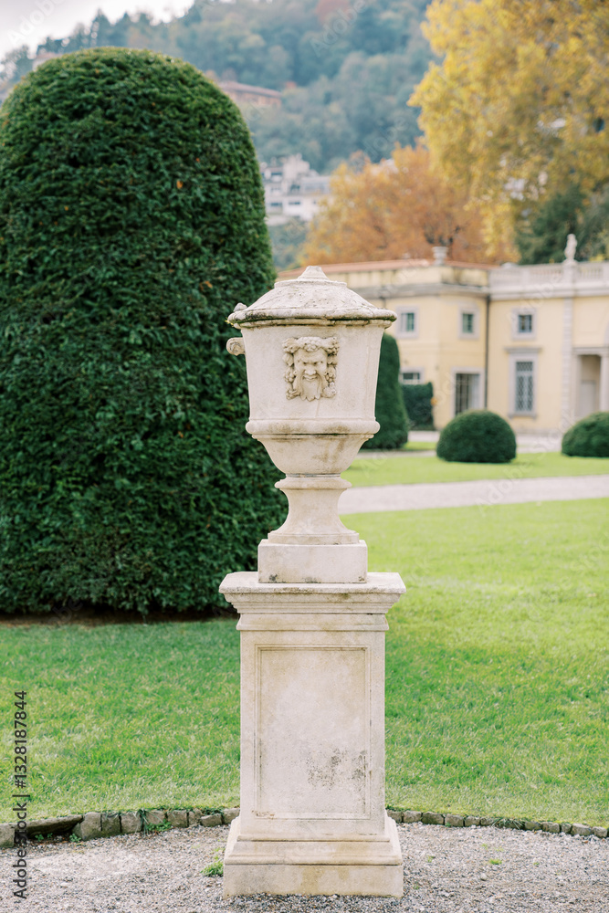 Marble flowerpot with lid in the green garden of an ancient villa Marble flowerpot with lid in the green garden of an ancient villa
