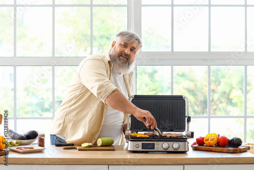 Mature man cooking tasty sa...