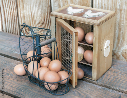 chicken eggs in a decorative box anf metal baskets on a table in front of a w...