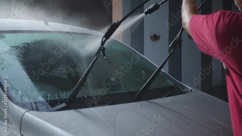 Washing car at home : people using high pressure cleaner to wash a car, with outdoor environment	