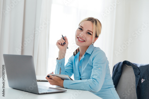 woman blonde at desk with laptop smiling in office online