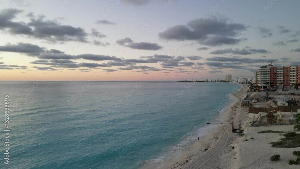 Sunset aerial view of Cancun beach with turquoise waters and scattered clouds in the sky, playa delfines
