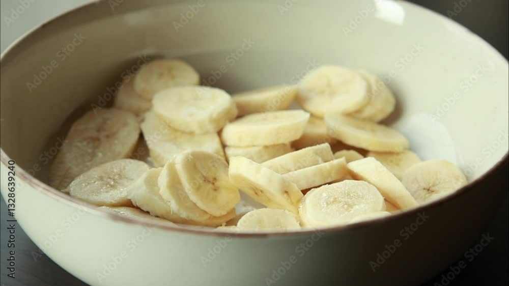 close-up of fresh banana being sliced into even pieces close-up of fresh banana being sliced into even pieces
