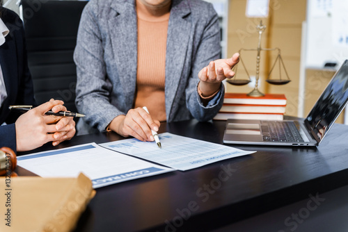 Wallpaper Mural Two female lawyers in business suits meet at wooden desk, shaking hands over contract paper. wooden gavel and scales justice as discuss legal compliance, corporate law, dispute resolution. Torontodigital.ca