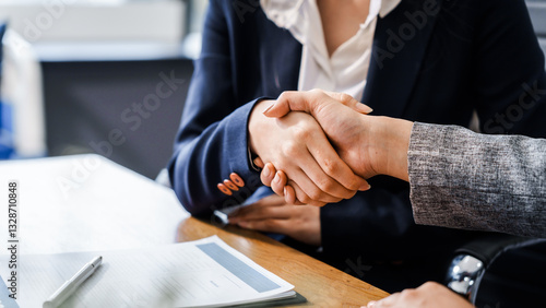 Wallpaper Mural Two female lawyers in business suits shake hands at wooden desk, finalizing legal agreement. wooden gavel and scales represent justice as they discuss corporate law, compliance, dispute resolution. Torontodigital.ca