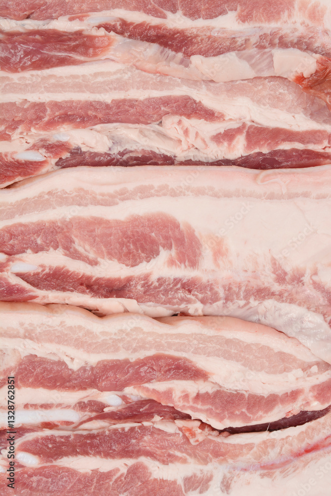 A close-up, top-down view of thick cuts of raw pork belly, showcasing the distinct layers of fat and meat A close-up, top-down view of thick cuts of raw pork belly, showcasing the distinct layers of fat and meat