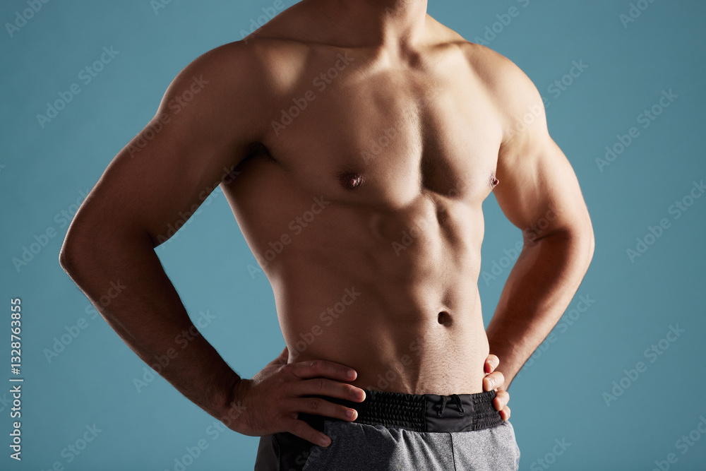 Closeup, shirtless and man in studio, muscular and fitness on blue background. Person, healthy physique and model with pecs, confidence and workout with training, bodybuilder and results for exercise Closeup, shirtless and man in studio, muscular and fitness on blue background. Person, healthy physique and model with pecs, confidence and workout with training, bodybuilder and results for exercise