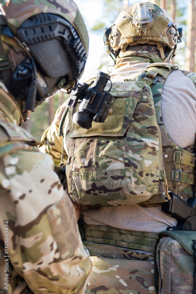 Fototapeta premium Soldiers in the forest. Military men in camouflage with weapons.
