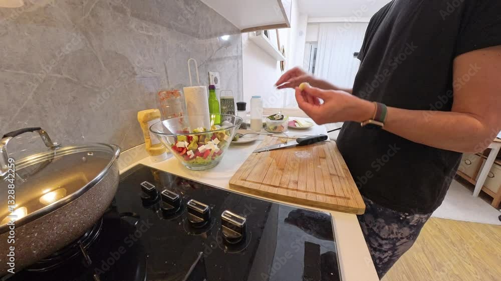 Side View of Woman Holding Cheese Slice Near Wooden Cutting Board with Salad Bowl and Ingredients on Kitchen Counter Side View of Woman Holding Cheese Slice Near Wooden Cutting Board with Salad Bowl and Ingredients on Kitchen Counter