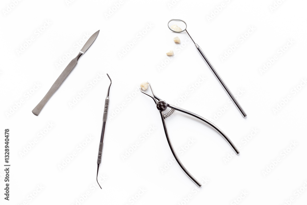 Obraz premium Dental crowns with steel instruments for dental prosthetics, top view. Dentist desk, white background
