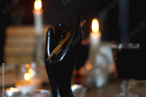 Books, lit candles, red wine, snacks and various deocration on the table. Dark academia or Halloween concept. Selective focus.