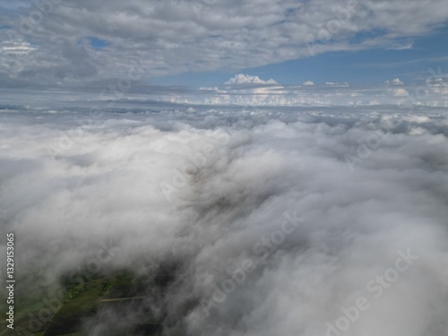 Aerial view of a landscape covered by clouds during the day