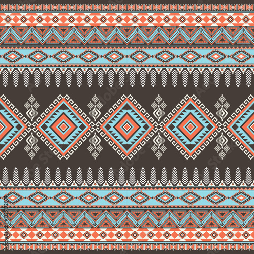 Abstract ethnic geometric texture pattern. Seamless blue and orange color of tribal abstract fabric textile on brown background