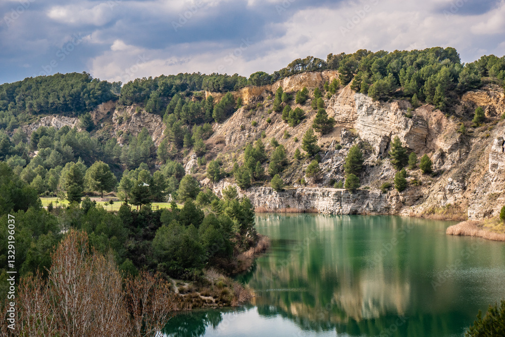 Fototapeta premium Beautiful turquoise lake next to an arid Mediterranean mountain with a recreational area.