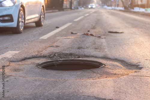 Canvastavla An open manhole on the road and a car driving dangerously close to it