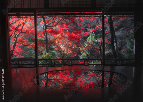 View of tranquil autumn scene with vibrant red leaves and serene reflection from a window, Arashiyama, Kyoto, Japan.