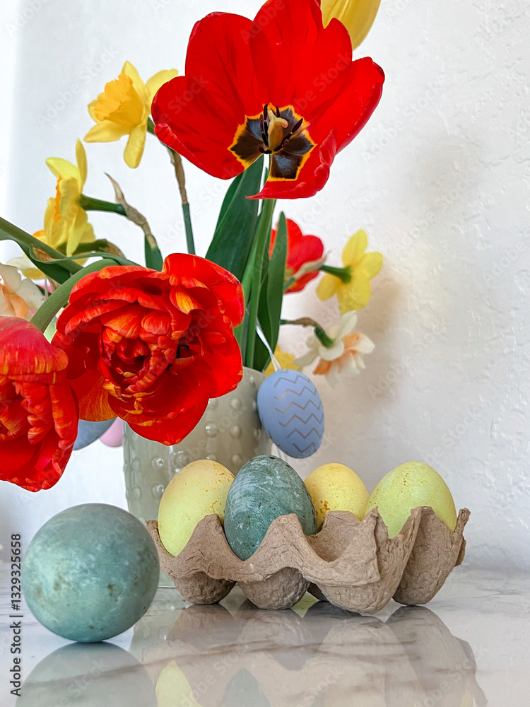 Bright colorful eggs are packed on the table next to a bouquet of tulips. An Easter card. Close. Vertical photography