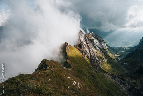 View of majestic mountains with clouds over a picturesque valley, Brulisau, Appenzell, Switzerland.