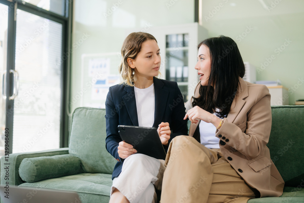 Two businesswomen strategizing with a tablet in a professional office. Highlight teamwork, leadership, Two businesswomen strategizing with a tablet in a professional office. Highlight teamwork, leadership,