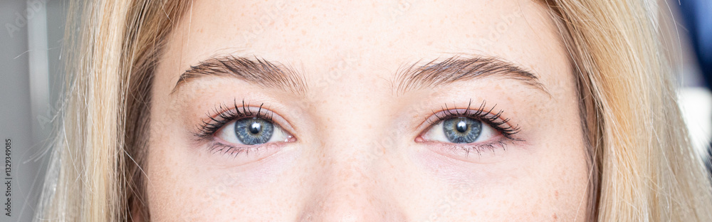 Naklejka premium Woman showing perfect eyebrows after microblading treatment