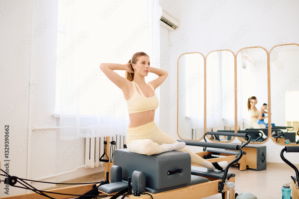 Focused engagement in a serene pilates studio with natural light and gentle ambiance Focused engagement in a serene pilates studio with natural light and gentle ambiance