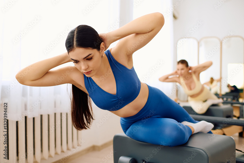 Fototapeta premium Focus and strength training in a modern pilates studio during a morning workout session