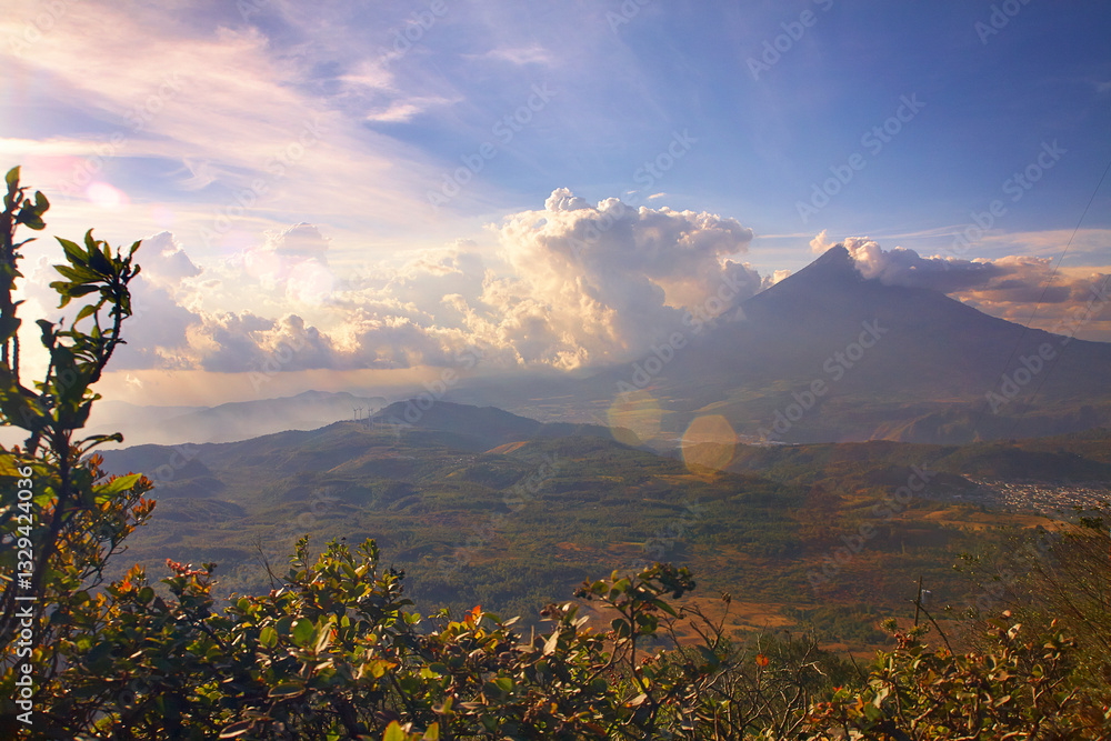 Fototapeta premium Atemberaubende Landschaftsaufnahme des Vulkans Pacaya in Guatemala bei dramatischer Bewölkung und warmem Licht. Das Bild vermittelt die Schönheit und Kraft der vulkanischen Landschaft Zentralamerikas.