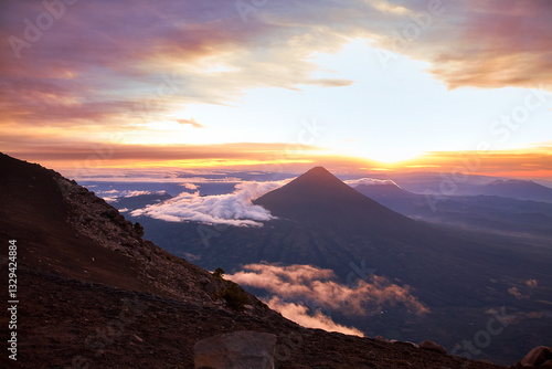 Eindrucksvolle Aufnahme des rauchenden Vulkans Fuego während einer Wanderung auf dem Vulkan Acatenango in Guatemala bei Sonnenuntergang.