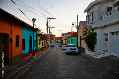 Eindrucksvolle Bilder der historischen Stadt Flores in Guatemala zur Abenddämmerung. Warme Sonnenstrahlen tauchen die Dächer und bunten Fassaden in ein goldenes Licht.