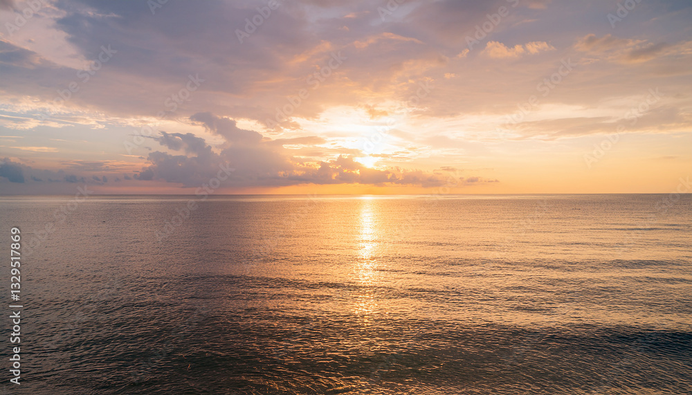 Naklejka premium Stunning Seascape Background: Golden Sunrise or Sunset Over Calm Ocean Waters with Colorful Sky and Reflective Light Path - Perfect for Travel, Wellness, and Inspirational Designs