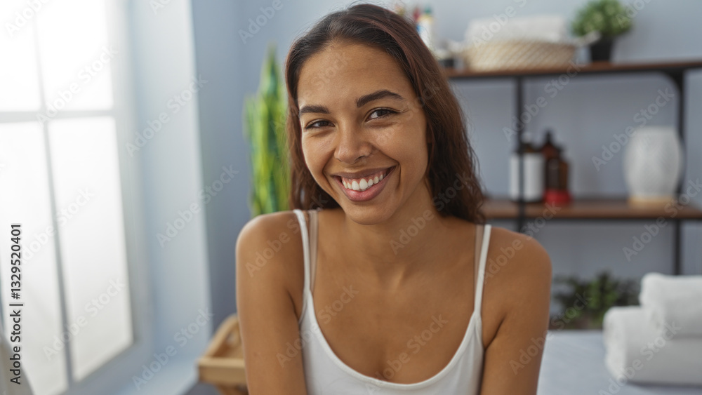 Woman smiling indoors at wellness center with shelves in the background, offering a serene spa environment filled with self-care products and a relaxed atmosphere. Woman smiling indoors at wellness center with shelves in the background, offering a serene spa environment filled with self-care products and a relaxed atmosphere.