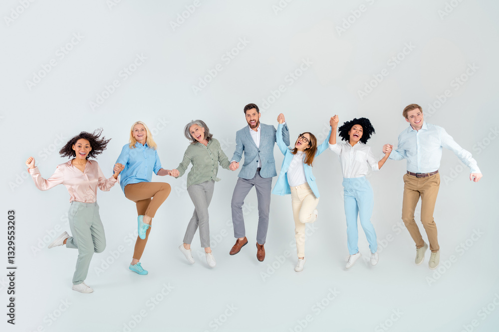 Obraz premium Diverse group of professional colleagues in formalwear smiling and celebrating together standing on light grey background