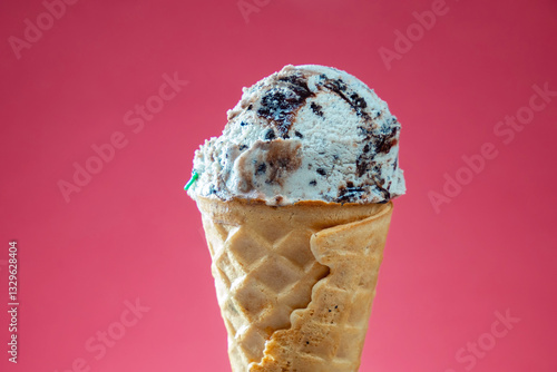 Ice cream cone with colorful sprinkles on red background. Close up.