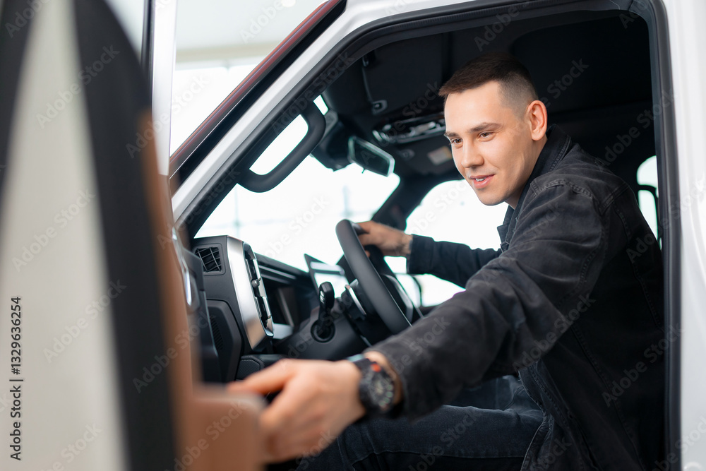 Young caucasian male exploring new vehicle interior at car dealership for purchase decision Young caucasian male exploring new vehicle interior at car dealership for purchase decision