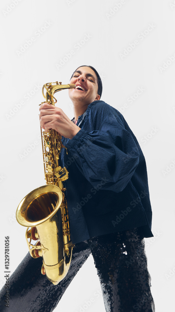 Fototapeta premium Joyful musician holding saxophone with broad smile, embracing moment of artistic passion against white studio background. Concept of music, joy, festival, talent, passion, performance.