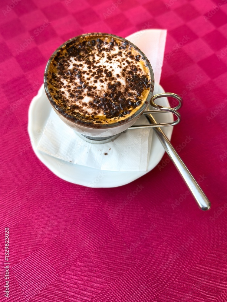 Cup of moccacino coffee with cream and chocolate server on table