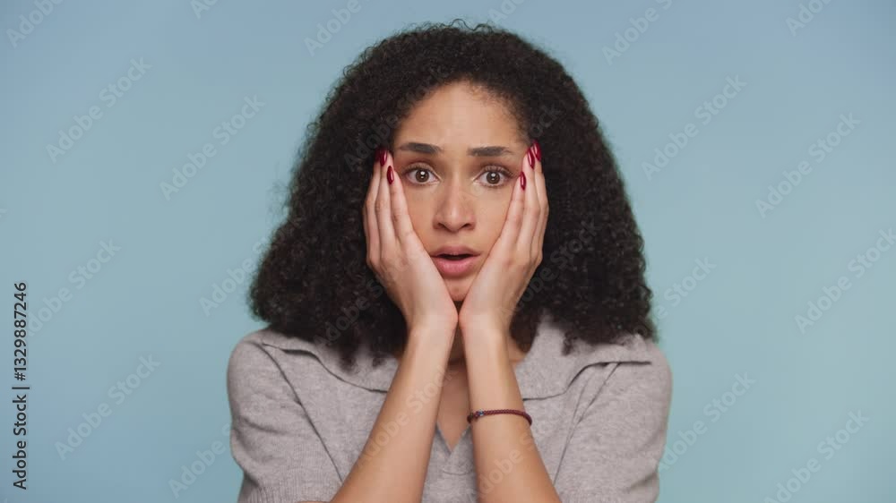 Shocked Woman Reacting to Unexpected News on Blue Background Shocked Woman Reacting to Unexpected News on Blue Background