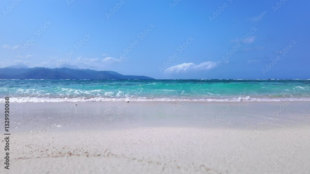 static shot of ocean with calm waves reaching shore of sand beach on tropical Gili island Indonesia during sunny day, holidays, vacations, relax, paradise and tourism concept, slow motion static shot of ocean with calm waves reaching shore of sand beach on tropical Gili island Indonesia during sunny day, holidays, vacations, relax, paradise and tourism concept, slow motion