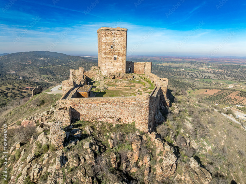 Aerial view of Feria castle in Spain, Gothic and Mudéjar style buildings, square keep, blue sky background