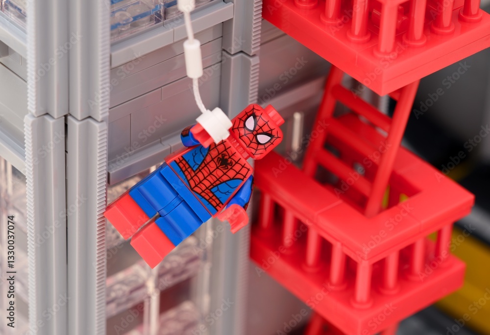 Naklejka premium Tambov, Russian Federation - January 06, 2025 A Lego Spiderman minifigure hanging from the web off the side of The Daily Bugle