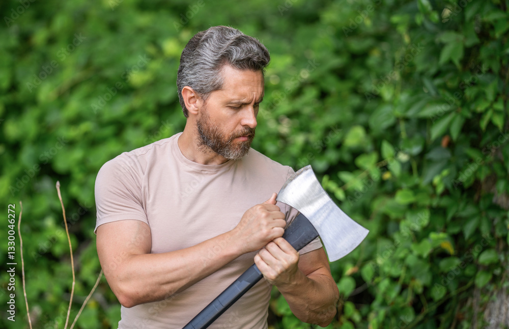 Fototapeta premium Hardworking brutal man checking sharp blade. Lumberjack hardworking outdoor. Brutal lumberjack. Brutality and masculinity. Hispanic lumberjack man with axe. Lumberjack axe. Man with logging axe