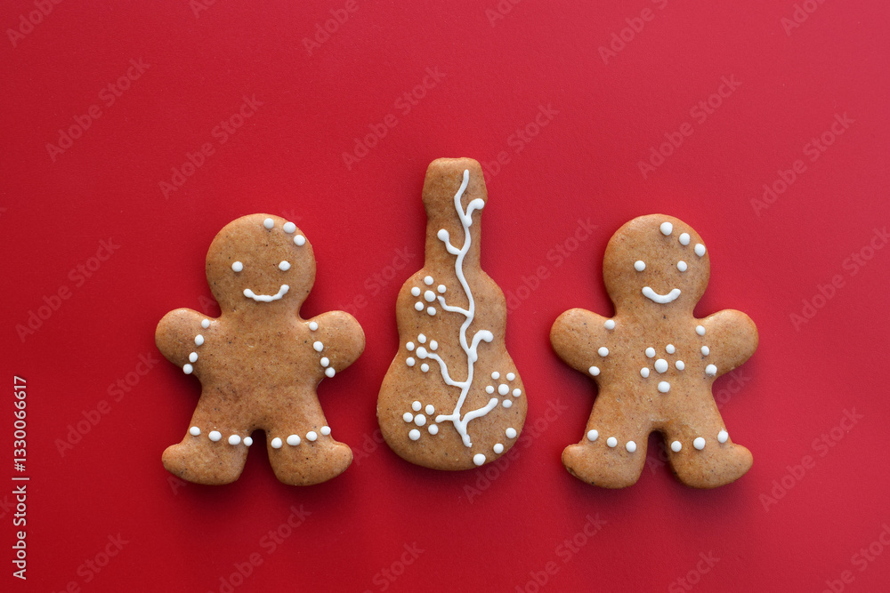 Romantic decorated gingerbread cookies in a shape of guitar and man, red background. Musical theme Romantic decorated gingerbread cookies in a shape of guitar and man, red background. Musical theme