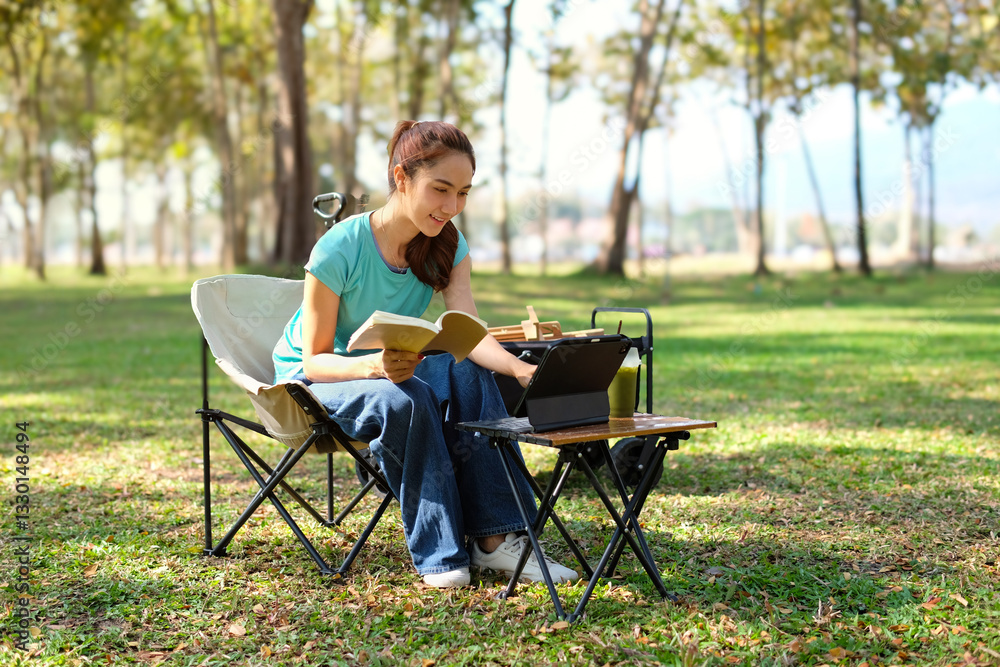 A young woman sits playing with a tablet in a quiet park. A young woman sits playing with a tablet in a quiet park.
