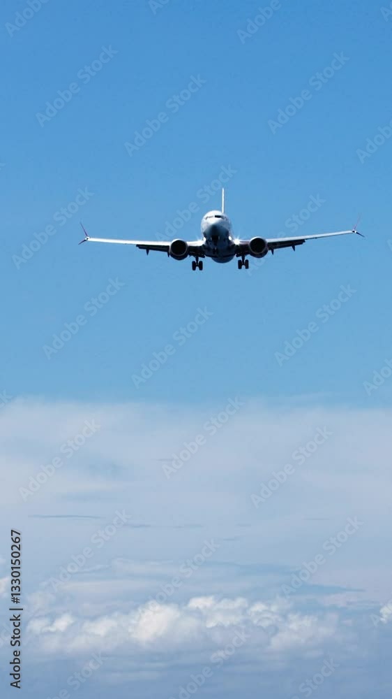 Vertical video.A passenger plane flies in the blue sky. View straight from below. Air travel, tourism and background concept. Vertical video.A passenger plane flies in the blue sky. View straight from below. Air travel, tourism and background concept.